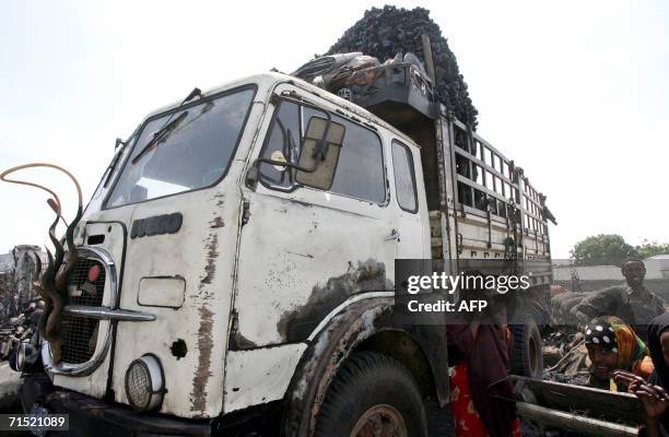 Somali girl covers her face as she sits behind a truck loaded with charcoal in Mogadishu 25 July 2006. A mystery plane 26 July delivered unknown...