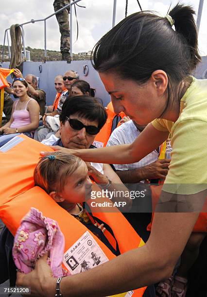 Frenchwoman Ghada Lenoir puts a life jacket on her 20-month-old daughter Eliana during their evacuation by the French navy aboard the amphibious war...