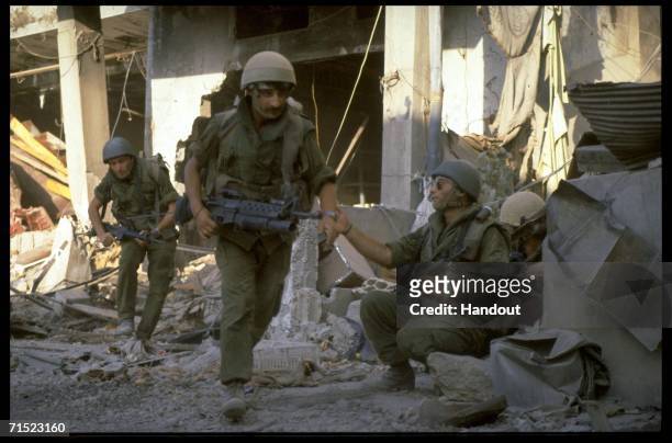In this archive image provided by the Israeli Government Press Office , Israeli army paratroopers advance against a suspected terrorist hide-out...