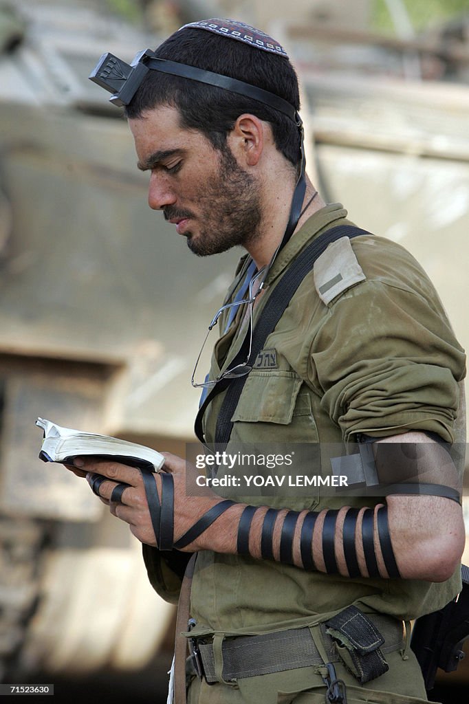 An Israeli soldier reads the Torah and p