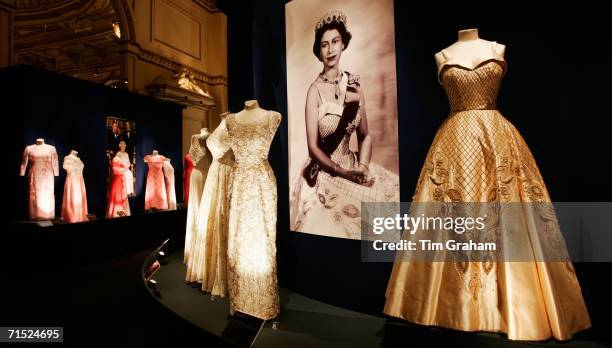 Duchesse satin and gold lame embroidered dress designed by Sir Norman Hartnell stands on display at an exhibition for the summer opening of the State...