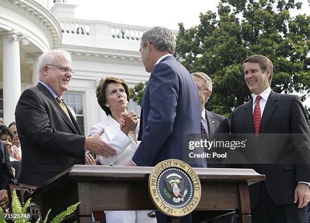 President George W. Bush shakes hands with House Minority Leader Nancy Pelosi after signing the H.R. 9, the Fannie Lou Hammer, Rosa Parks, and...