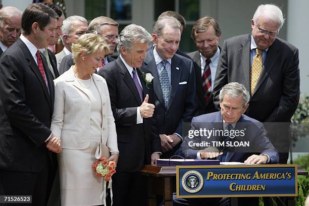 Washington, UNITED STATES: US President George W. Bush signs H.R. 4472, the Adam Walsh Child Protection and Safety Act of 2006 joined by John Walsh...