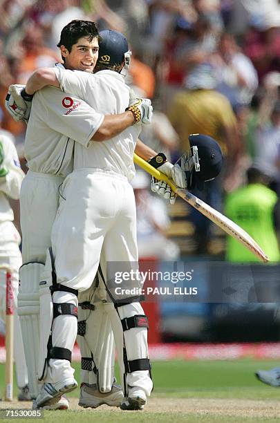 Manchester, UNITED KINGDOM: England's Alastair Cook celebrates with teammate Paul Collingwood reaching 100 not out against Pakistan on the second day...