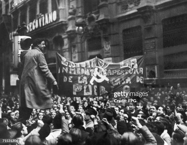 The Communist hammer and sickle symbol appear at a demonstration in Madrid, circa 1936. A banner demands the immediate reopening of the Casa del...