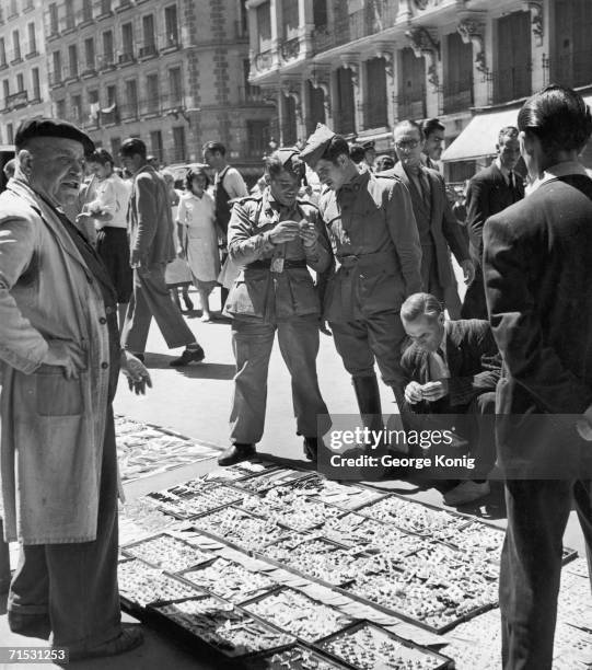 Customers shopping for cheap buttons at El Rastro flea market, Madrid, June 1950.