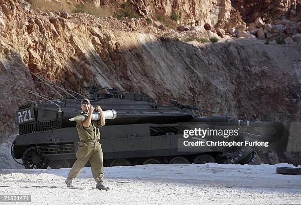 An Israeli Merkava tank crewman loads his vehicle with ammunition in a holding area near to the Israeli-Lebanon border on July 28 at a forward base...