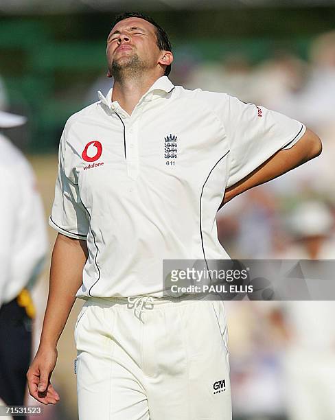 Manchester, UNITED KINGDOM: England's Steven Harmison holds his side after bowling to Pakistan's Imran Farhat on the second day of their second...