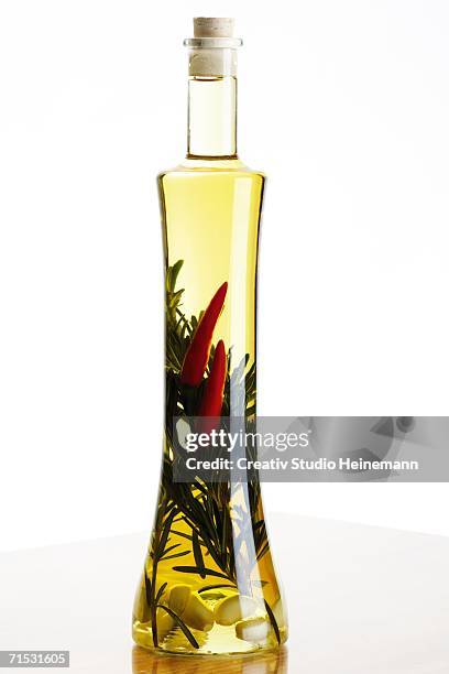 bottle of olive oil with herbs and spices, close-up - aceitera fotografías e imágenes de stock