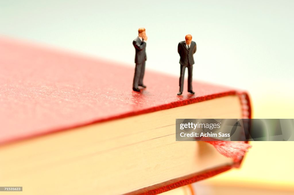 Figurine of man kept on book, close-up