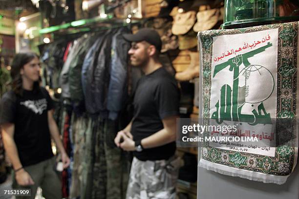 Customer talks with a shop assistant next to a Lebanese Islamic Shiite group Hezbollah pennant at an military supply shop, in Sao Paulo, Brazil, 28...