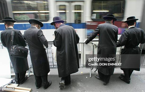 New York, UNITED STATES: Orthodox Jewish men stand together during a rally 28 July 2006 outside the Israeli Consulate in New York against Israel's...