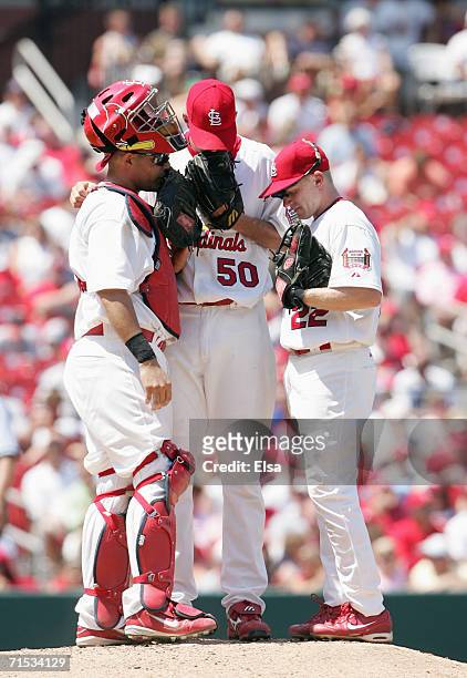 Pitcher Adam Wainwright, David Eckstein and catcher Yadier Molina of the St. Louis Cardinals meet on the mound during the game against the Los...