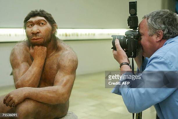 File picture taken 28 July 2004 shows a photographer taking pictures of the Neanderthal man ancestor's reconstruction, displayed in a show of the...