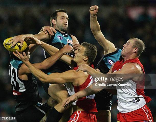 Darryl Wakelin of Port spoils the ball over Ted Richards and Barry Hall of Swans during the round 17 AFL match between the Port Adelaide Power and...