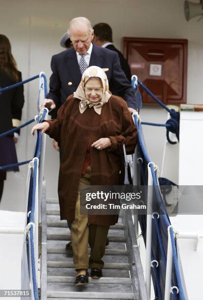 Queen Elizabeth II in suede coat, headscarf and trousers with Prince Philip, Duke of Edinburgh leave the Hebridean Princess at Stornoway after a...