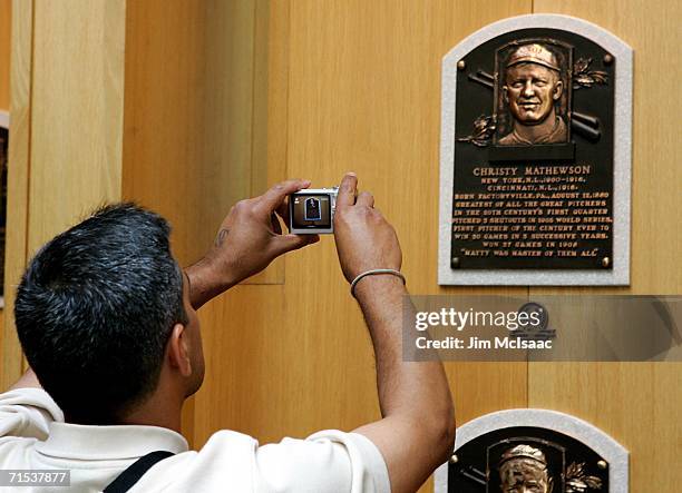 Baseball fan photograghs the plaque of Christy Mathewson at the National Baseball Hall of Fame and Museum during the Baseball Hall of Fame weekend on...