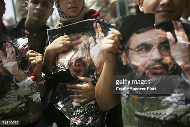 Lebanese peole hold up pictures of Sheik Hassan Nasrallah, the leader of Hezbollah, as thousands protest in front of the United Nations headquarters...