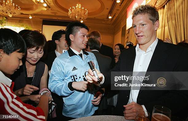 Bastian Schweinsteiger of FC Bayern Munich signs autographs for fans at a reception party on their Japan tour on July 30, 2006 in Tokyo, Japan....