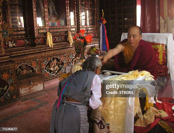Tibetan Buddhist devotee is blessed by His Holiness Gyonjang Rinpoche an incarnate monk of the royal shrine with holy water on the occassion of...