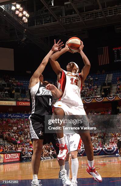 Asjha Jones of the Connecticut Sun goes to the basket against Jae Cross of the San Antonio Stars at Mohegan Sun Arena on July 30, 2006 in Uncasville,...