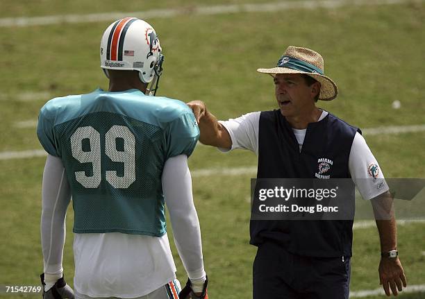 Head coach Nick Saban of the Miami Dolphins talks with defensive end Jason Taylor after a drill during training camp at Nova Southeastern University...