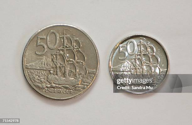 The new 50 cent piece which began circulation for the first time today sits next to the older, larger coin, July 31, 2006 in Auckland, New Zealand....