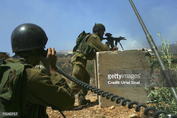 Israeli soldiers secure the area as they try to recover a disabled Israeli tank after it was hit by a Hezbollah rocket in Kafar Kila on July 31, 2006...