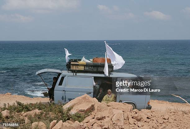 Lebanese refugees fleeing in a van display white flags as they the drive toward Tyre July 31, 2006 on the road from Bint Jbail, southern Lebanon. The...