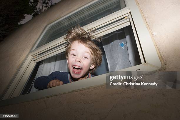 boy peeking out of window at night - gestalt stock-fotos und bilder