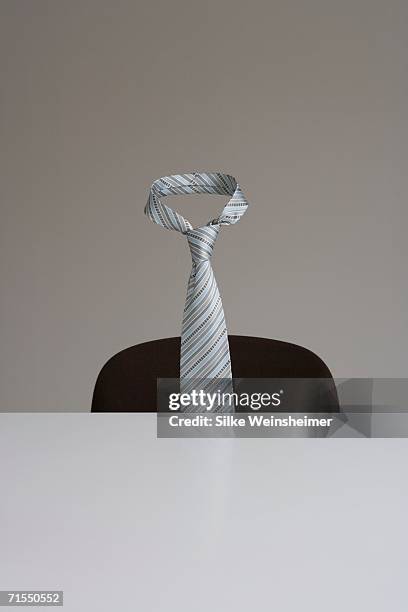 tie floating in mid-air behind desk - krawatte stock-fotos und bilder