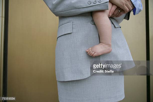 a businesswoman holding a baby - working mother 個照片及圖片檔
