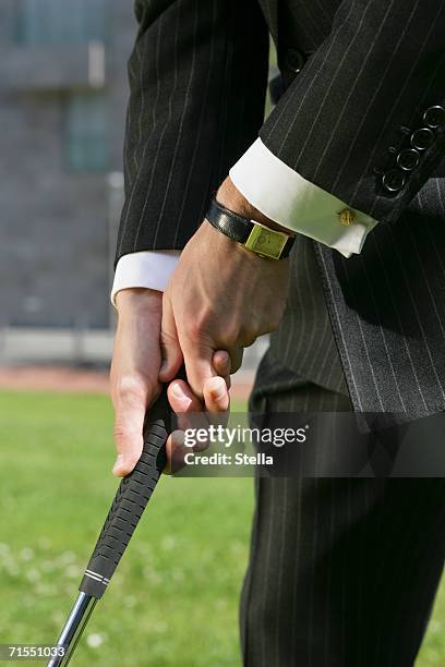 a businessman holding a putter - cufflink fotografías e imágenes de stock