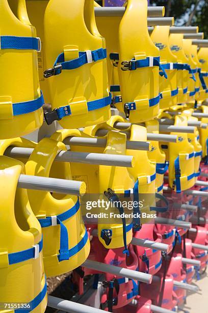 life jackets arranged on rack - nobod stock pictures, royalty-free photos & images