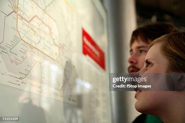 two young adults looking at a subway map, berlin, germany - looking at subway map bildbanksfoton och bilder