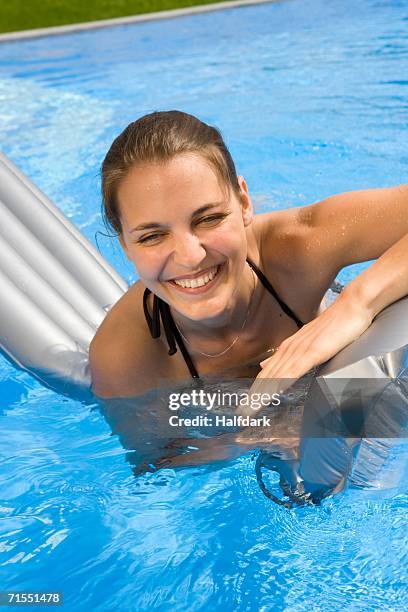 Woman In Inflatable Raft A Young Woman Playing On An Inflatable Raft In A Swimming Pool High-Res ...