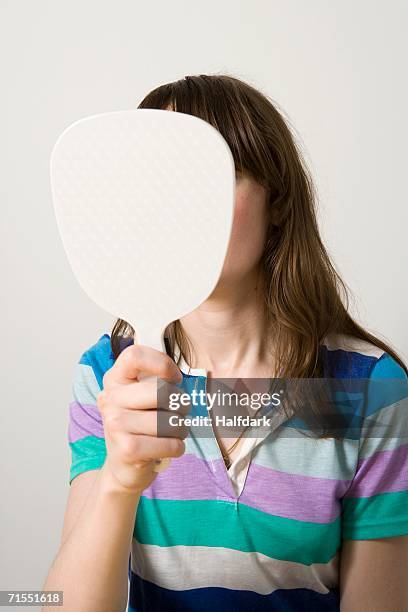 young woman holding mirror - handspiegel stock-fotos und bilder