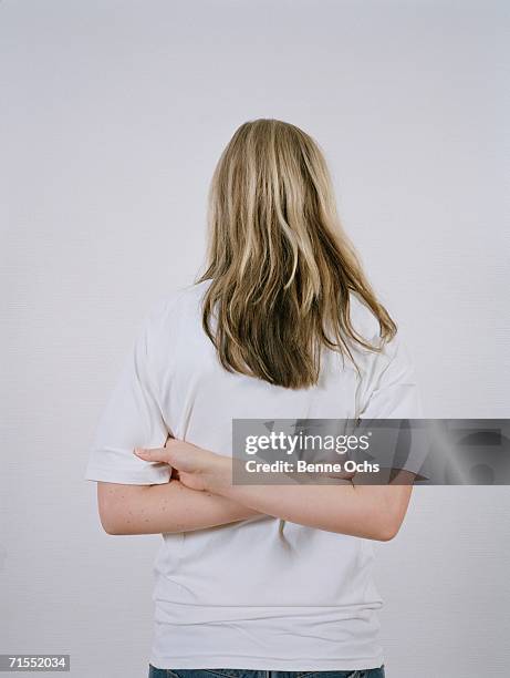 young woman with arms crossed behind her back - blonde hair rear white background stock pictures, royalty-free photos & images