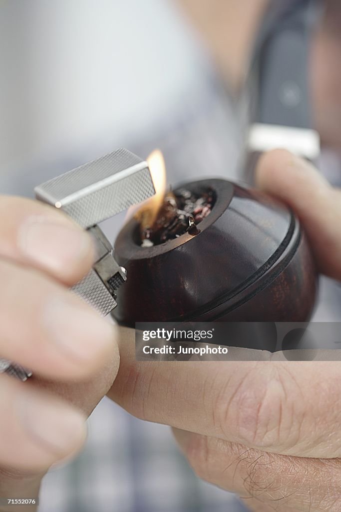 Mature man lighting a pipe