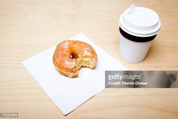 cup of coffee and donut with missing bite - coffee cup disposable stock pictures, royalty-free photos & images
