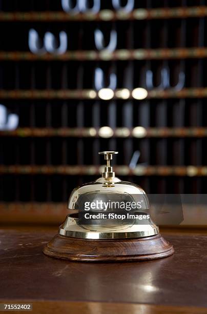 brass bell on desk at hotel reception - receptiebel stockfoto's en -beelden
