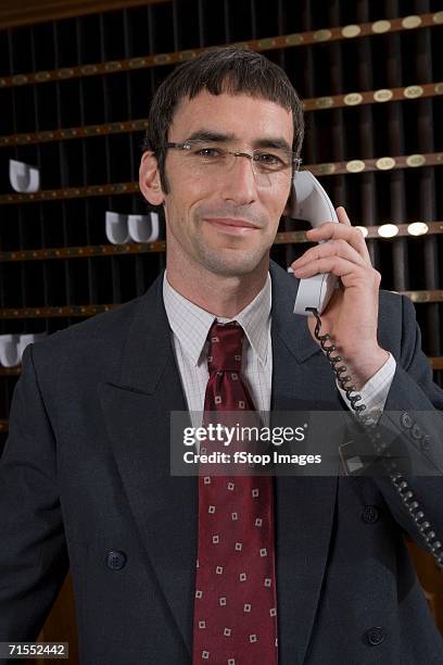 hotel clerk using telephone at reception - pigeon hole stock pictures, royalty-free photos & images