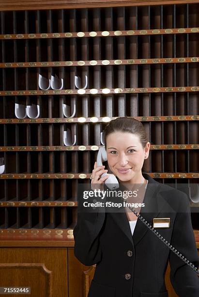 hotel clerk using telephone at hotel reception - pigeon hole stock pictures, royalty-free photos & images