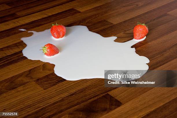 strawberries in puddle of spilt milk - spilt milk stock pictures, royalty-free photos & images