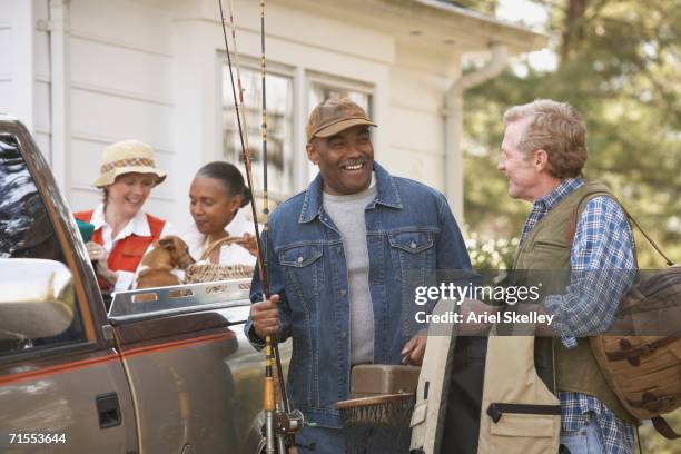 middle-aged friends carrying fishing equipment - 50 59 years stock pictures, royalty-free photos & images