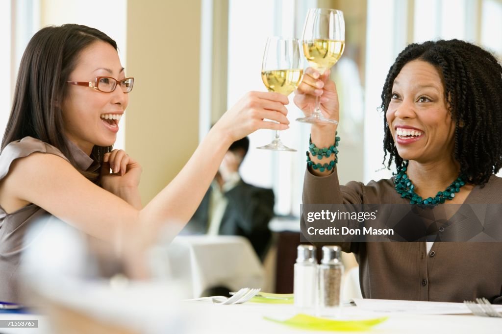 Two businesswomen toasting in restaurant