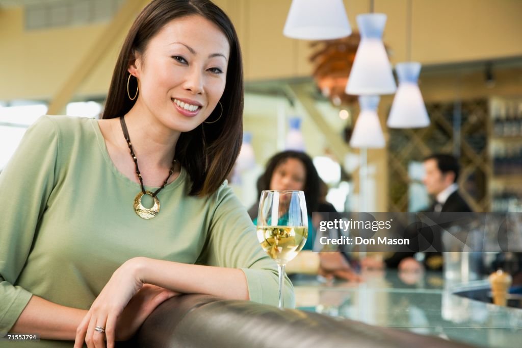 Woman at bar with glass of wine