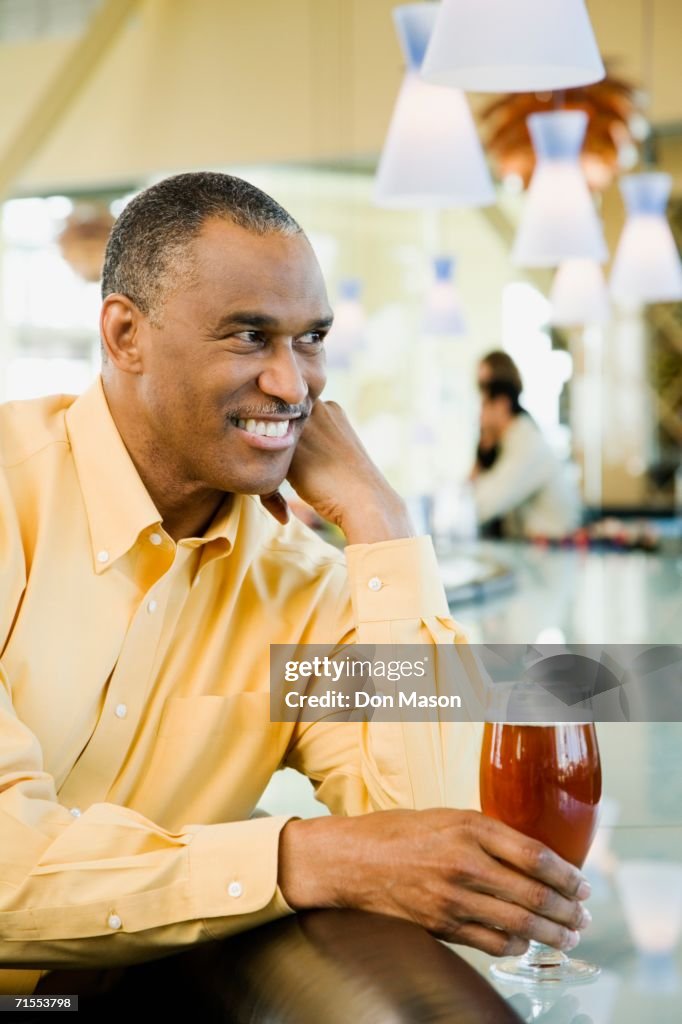 African American man with drink at bar