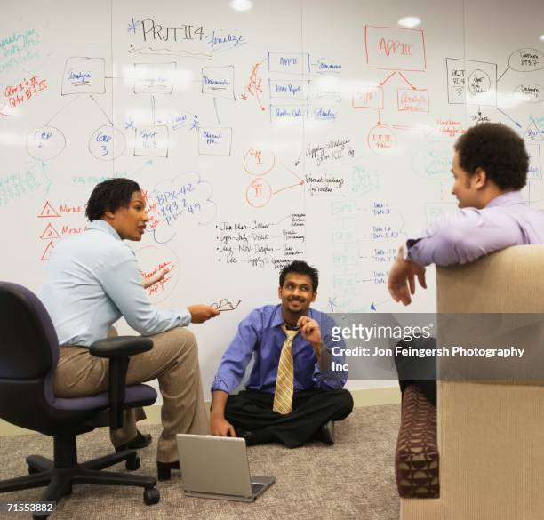 businesspeople having a meeting in front of a whiteboard wall - exigir fotografías e imágenes de stock