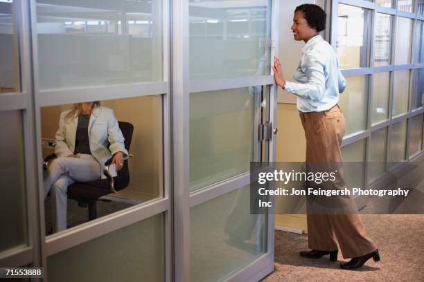 two female coworkers talking in office - office doorway stock pictures, royalty-free photos & images